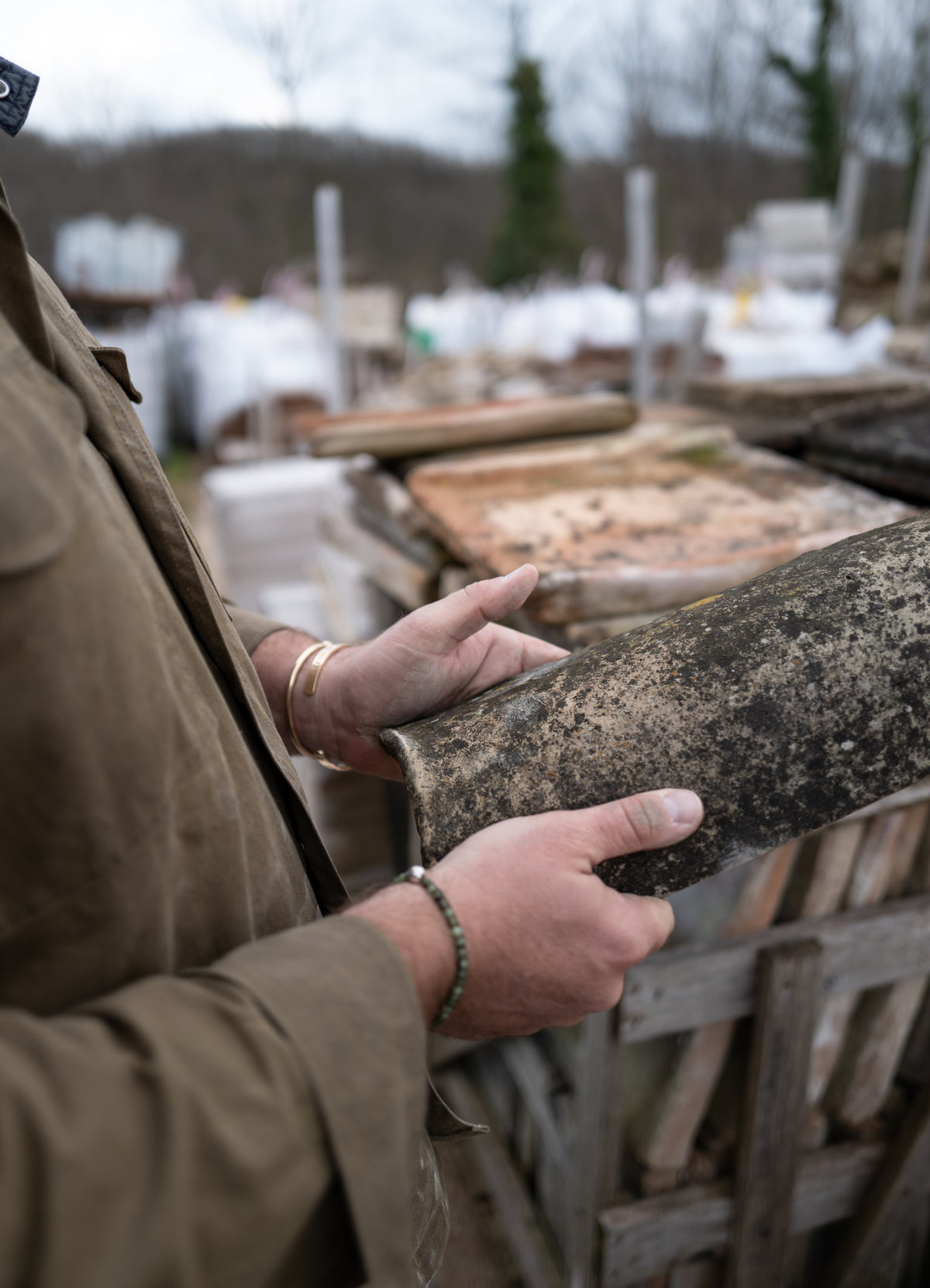 Inspecting a reclaimed French roof tile at the source yard