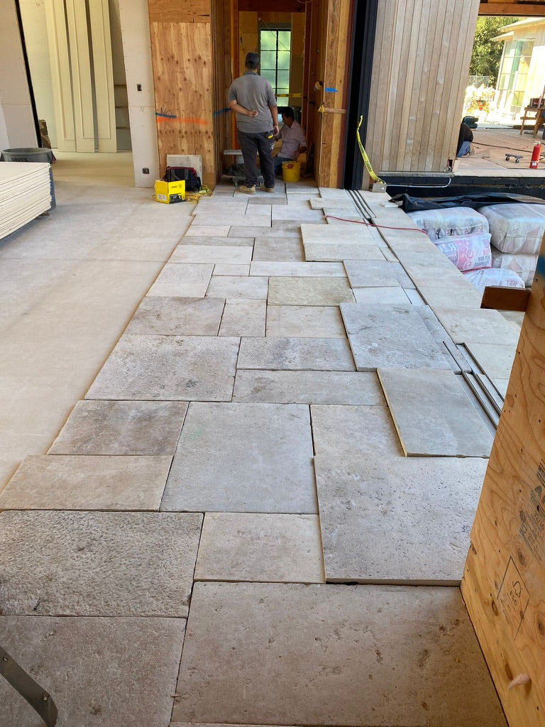Reclaimed Basilica Italian limestone being laid in a new home