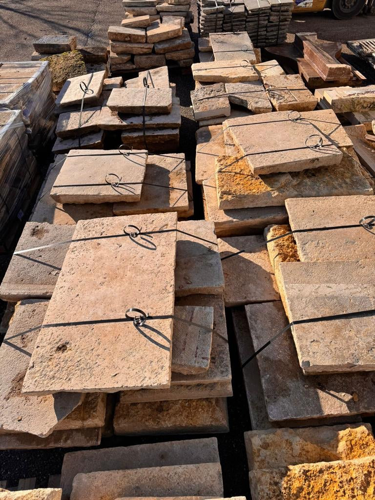 Reclaimed Dalle de Bourgogne limestone strapped on pallets in the yard