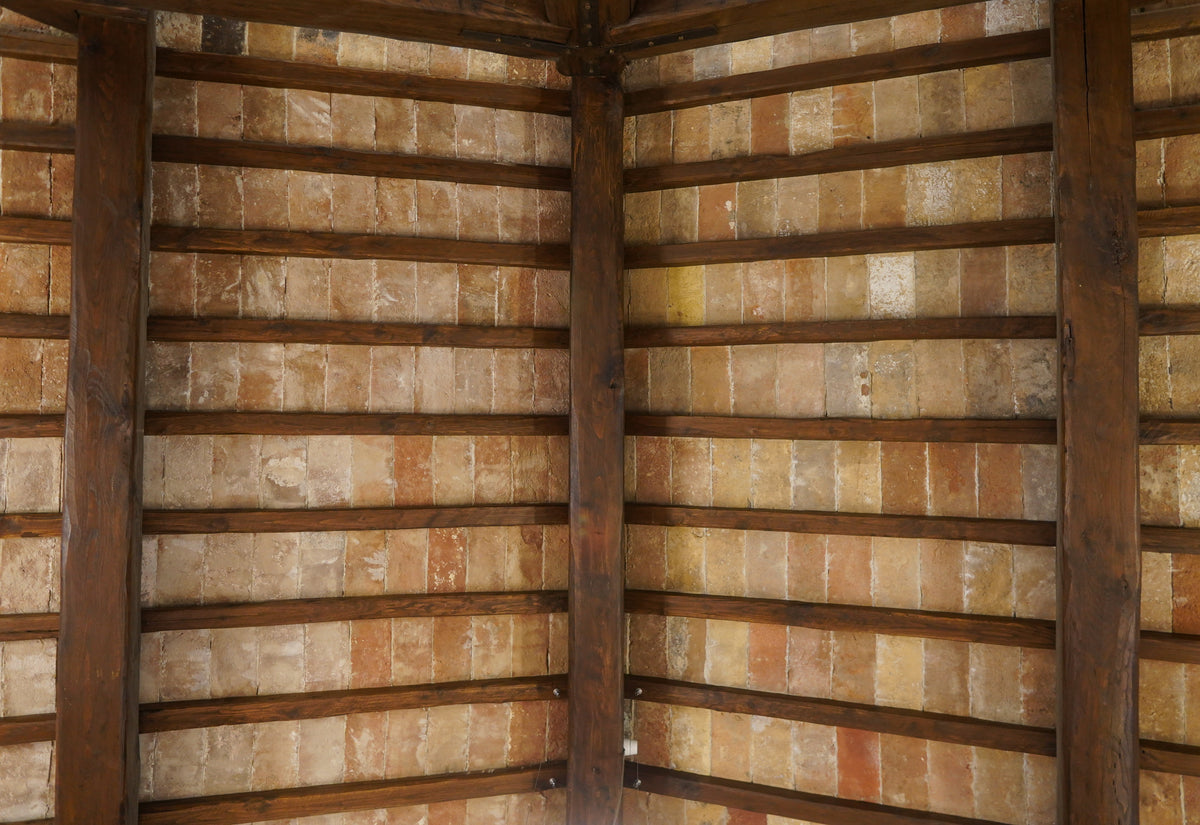 Reclaimed terracotta parefeuille set between oak rafters in a ceiling