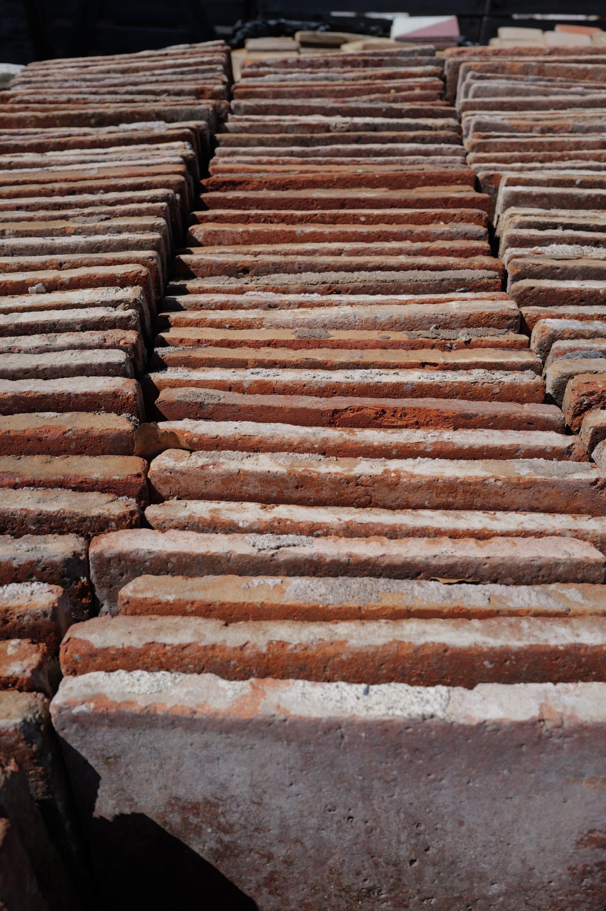 Rows of reclaimed French terracotta tiles stacked on edge