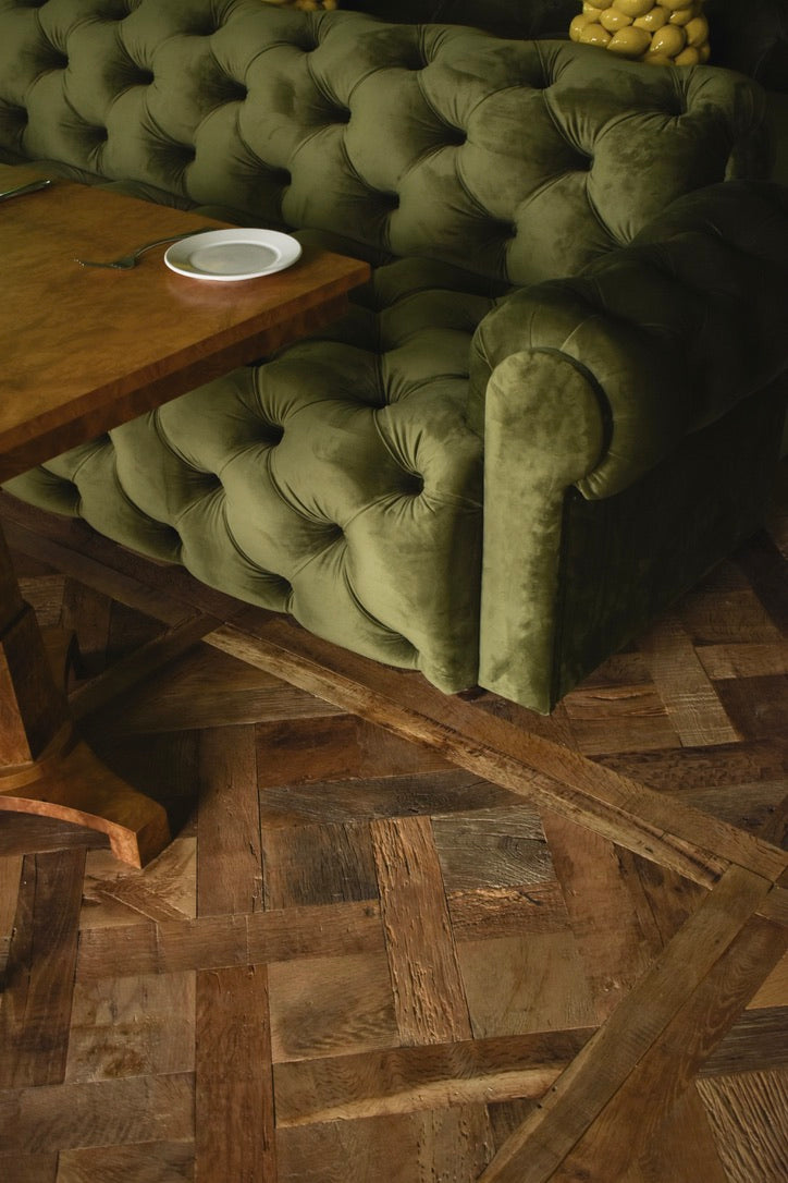 Versailles panel floor with green tufted sofa