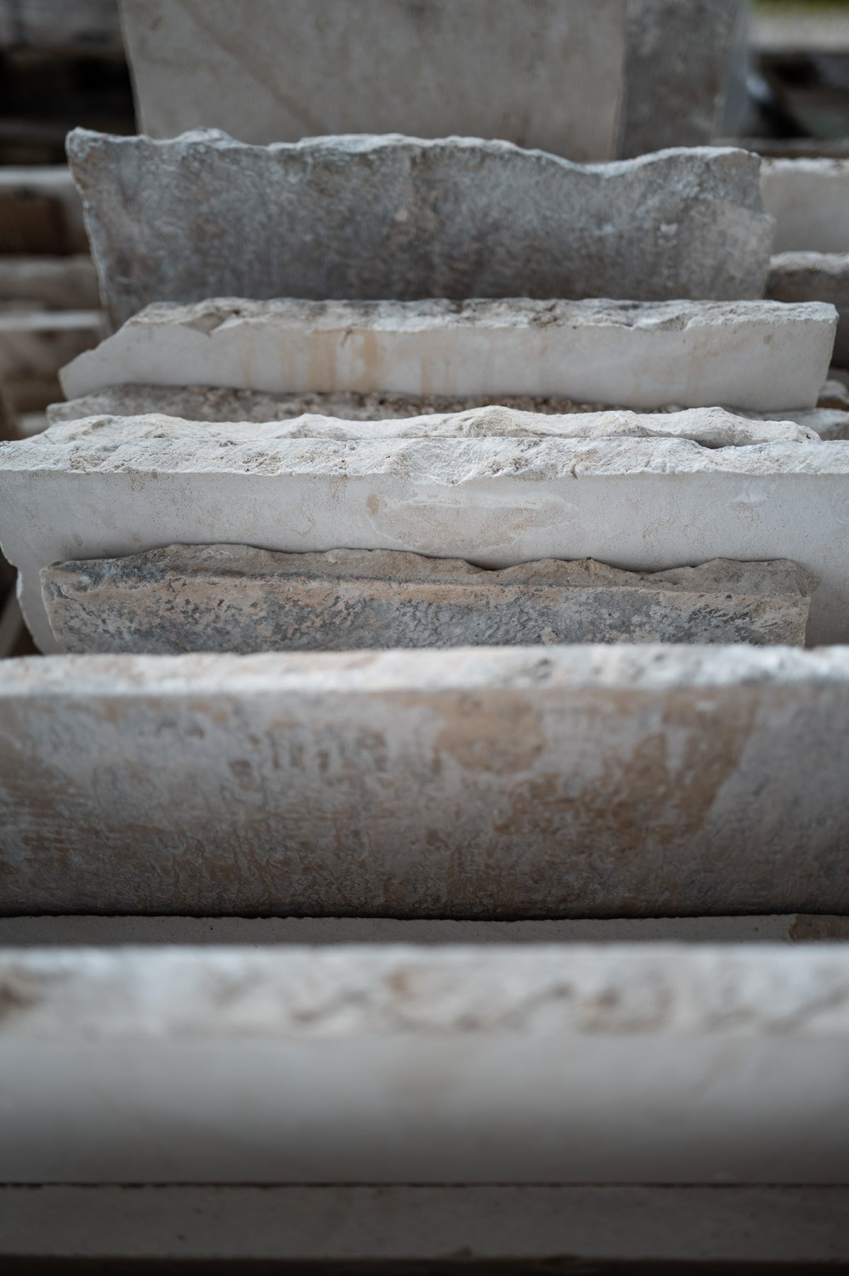 Stacked reclaimed limestone slabs showing worn edges