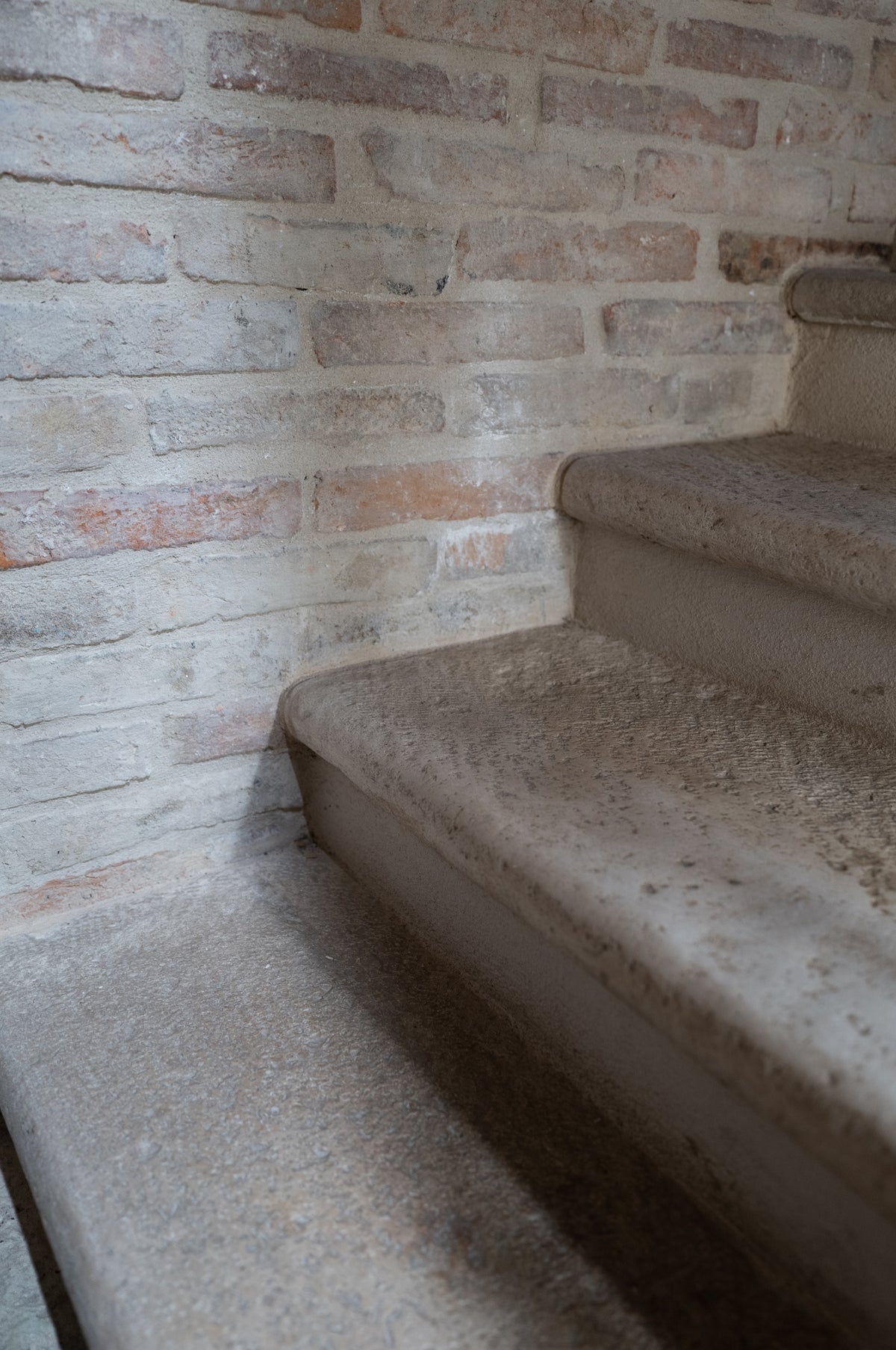 Reclaimed Basilica limestone stair treads against an old brick wall