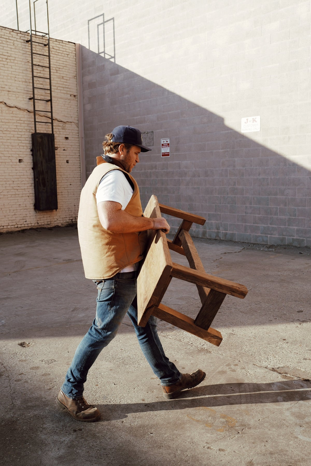 Carrying a custom reclaimed French oak table across the yard