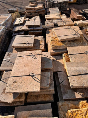 Reclaimed Dalle de Bourgogne limestone strapped on pallets in the yard
