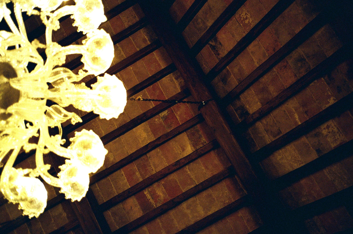Reclaimed French oak beams and terracotta ceiling beneath a Murano chandelier