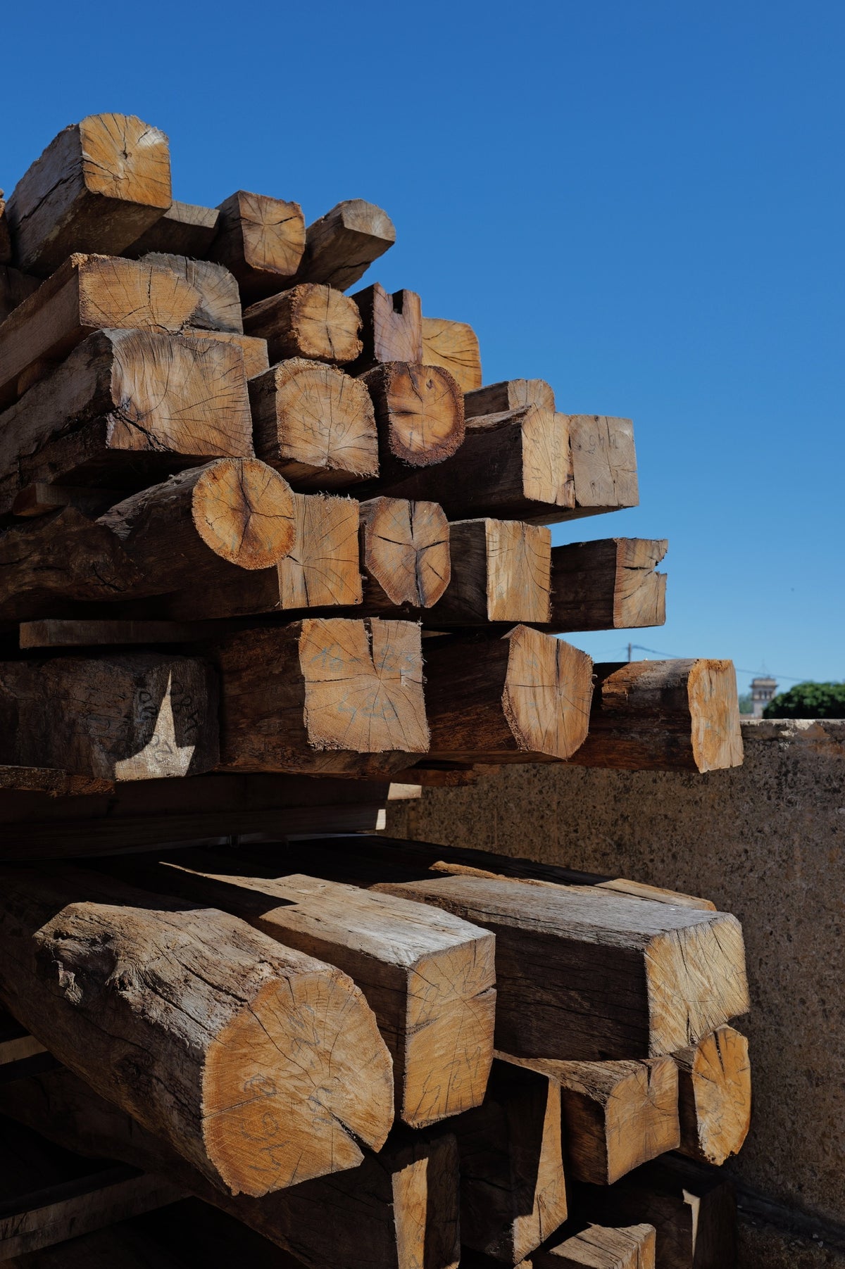 Stack of reclaimed French oak beams showing end grain