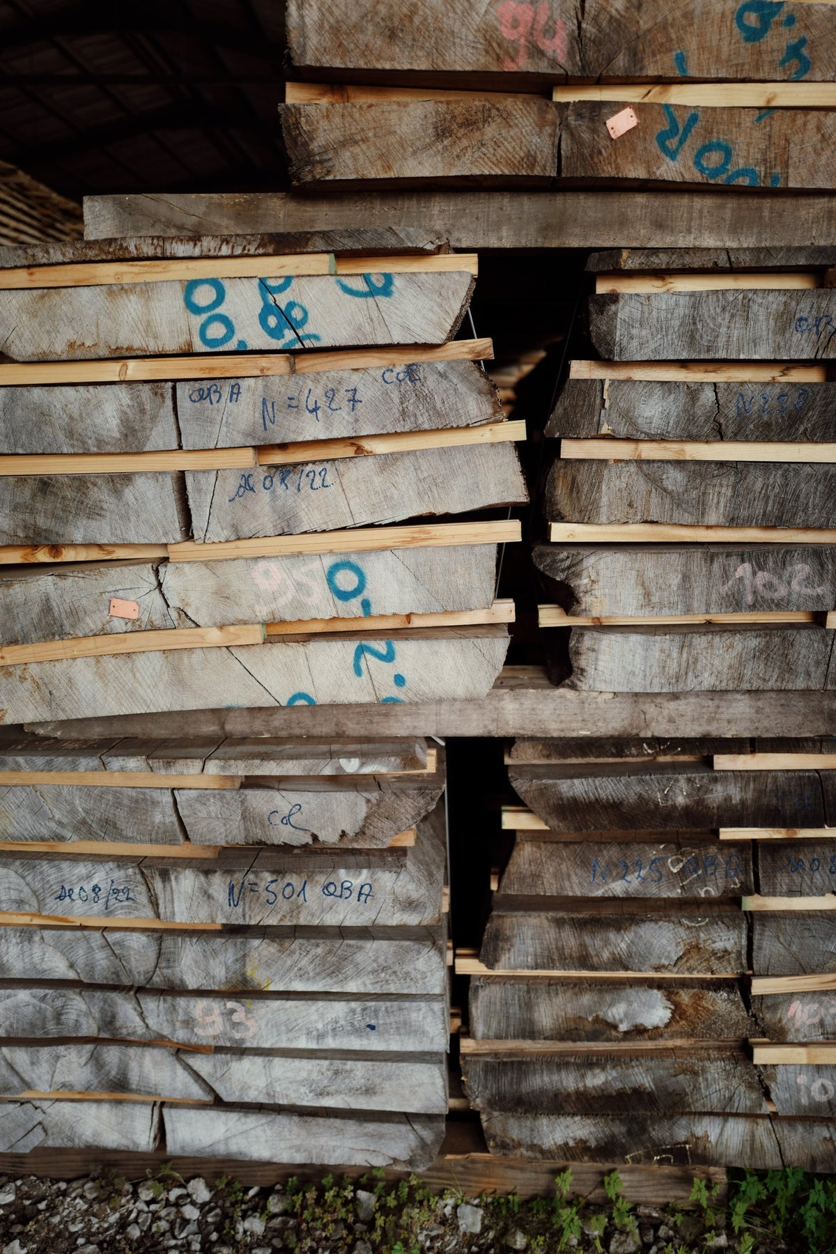 Stacked French oak boards air-drying, marked by lot