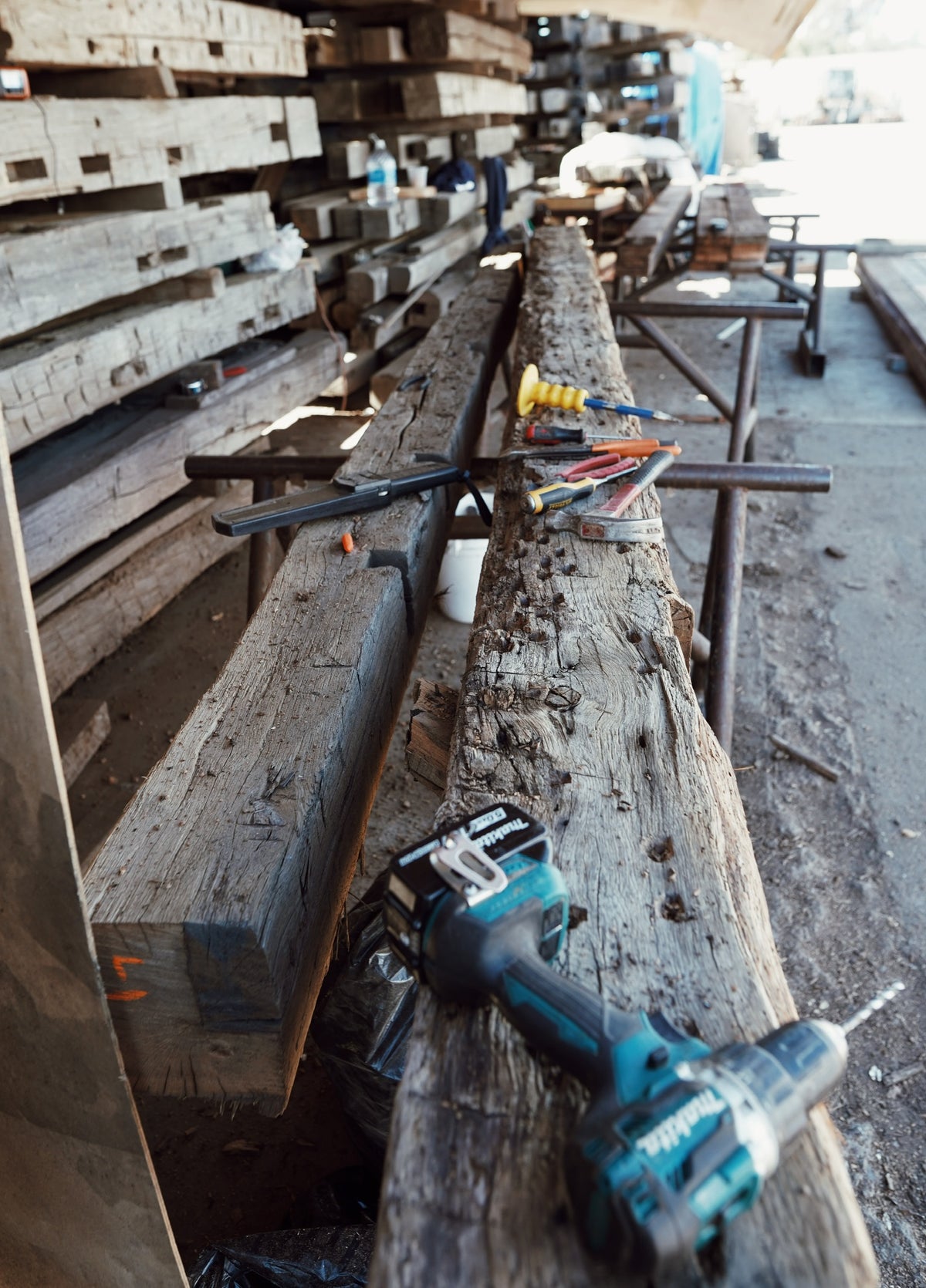 Denailing hand hewn reclaimed oak beams in the yard