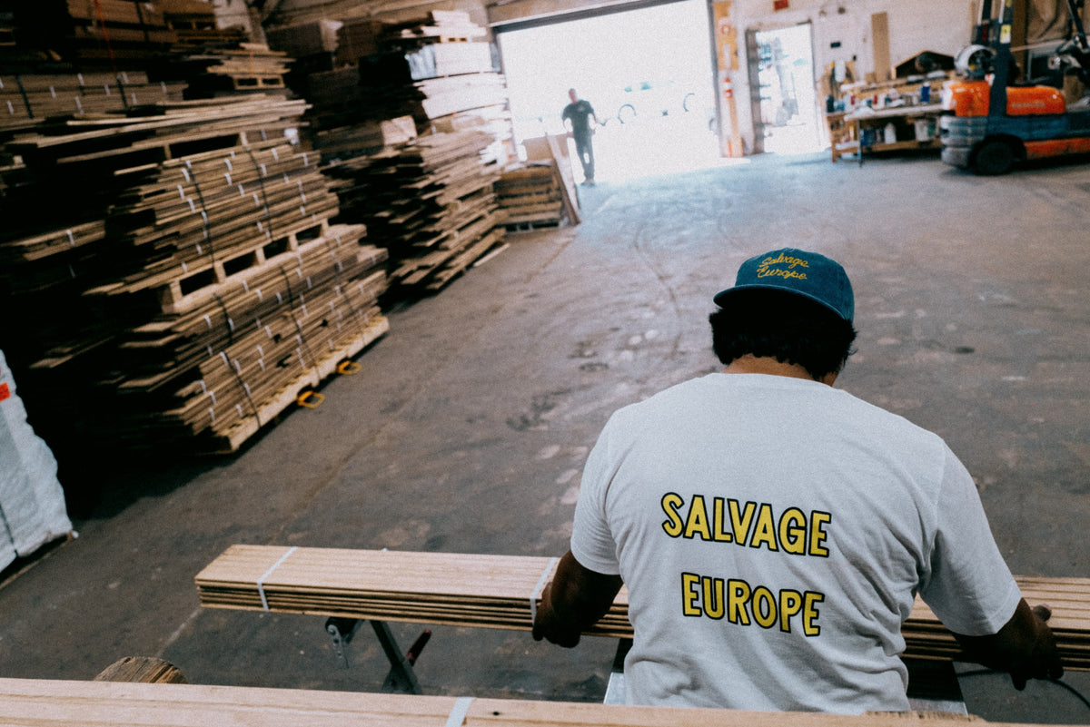 Salvage Europe team member cutting reclaimed oak in the Los Angeles warehouse