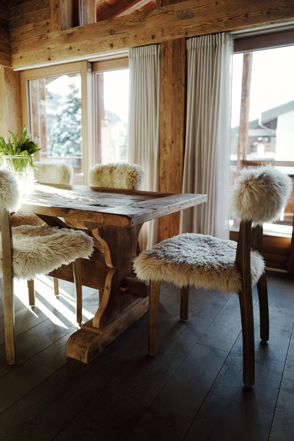 Custom reclaimed French oak trestle dining table in an Alpine chalet