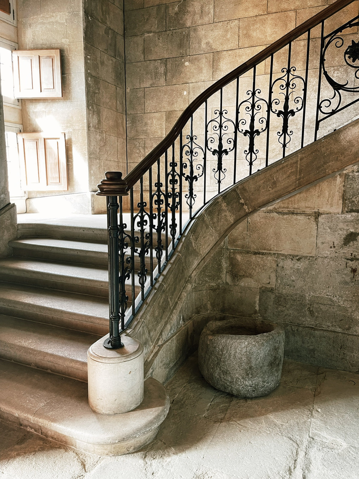 Worn limestone staircase and stone walls in an old French house