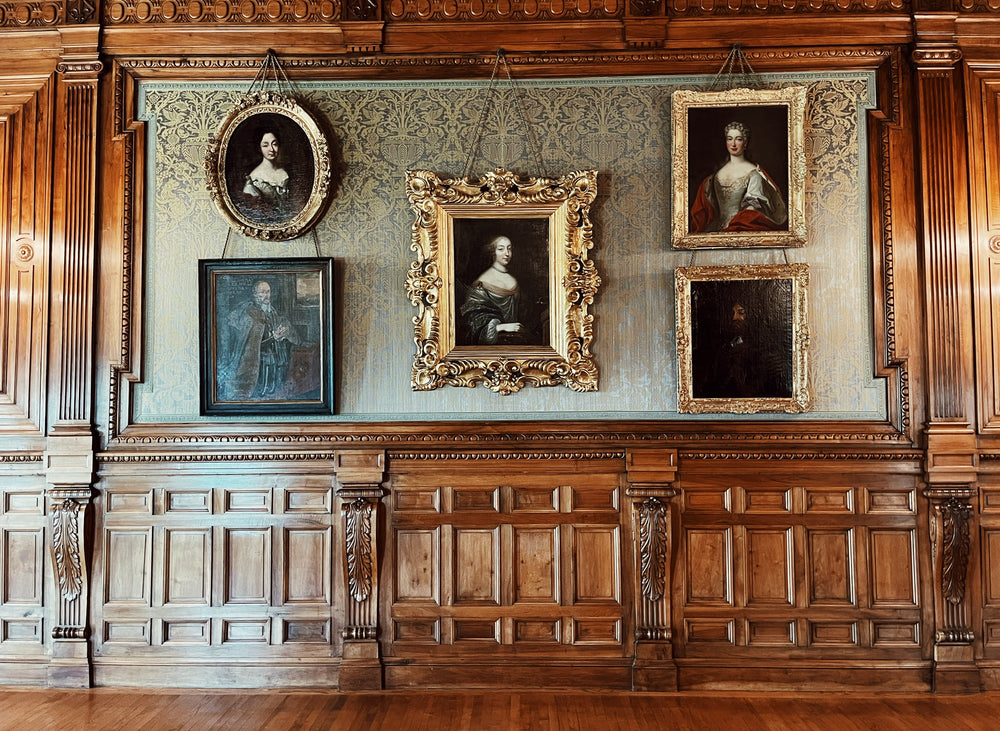 French chateau gallery with carved walnut panelling and gilt-framed portraits