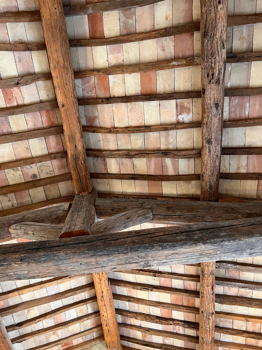 Provencal farmhouse ceiling of antique beams and terracotta tiles