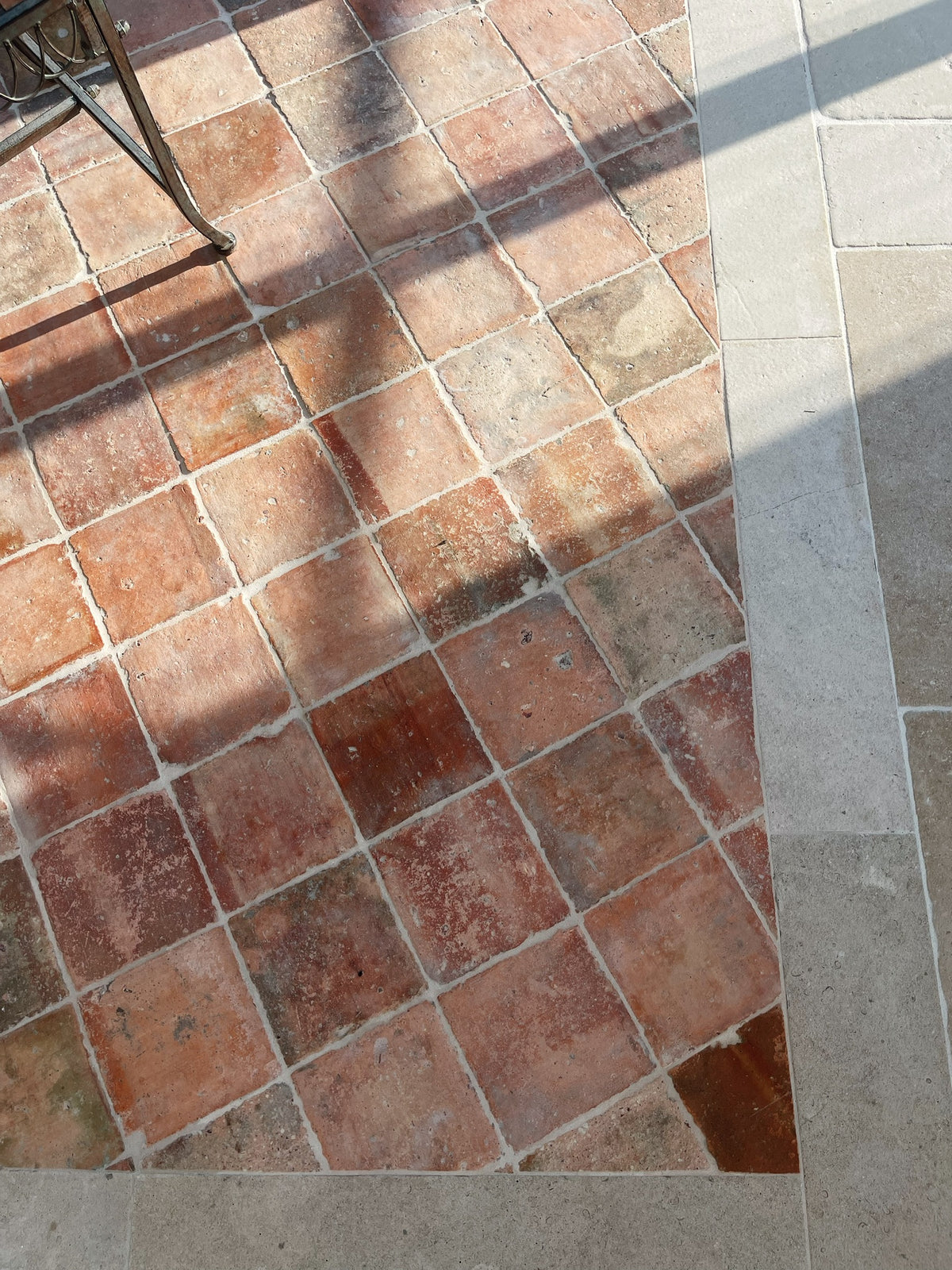 Reclaimed French terracotta tiles laid on the diagonal with a limestone border